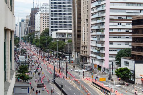 Free Panoramic view of a vibrant São Paulo street on a busy day with cyclists and city skyscrapers. Stock Photo