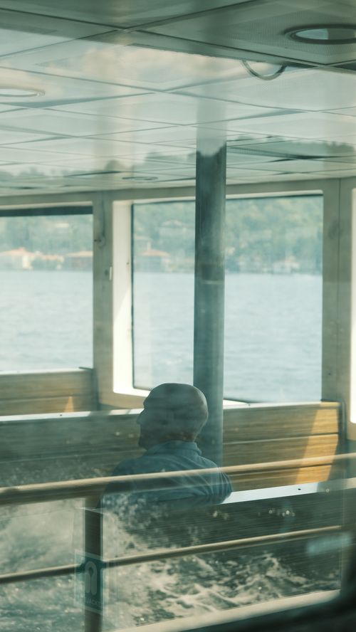Free A peaceful journey on a ferry with a scenic lake view and reflections. Stock Photo