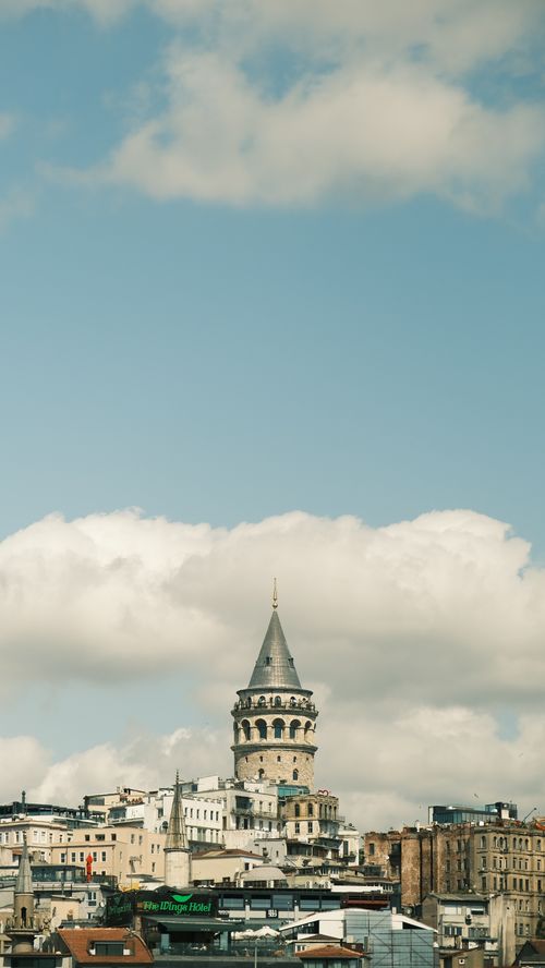 Free View of the historic Galata Tower with cityscape under a cloudy sky in Istanbul, Turkey. Stock Photo