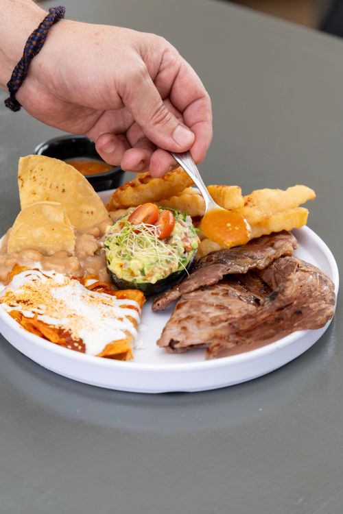 Free A gourmet Mexican platter featuring meats, guacamole, and fries. Perfect for a delicious meal. Stock Photo
