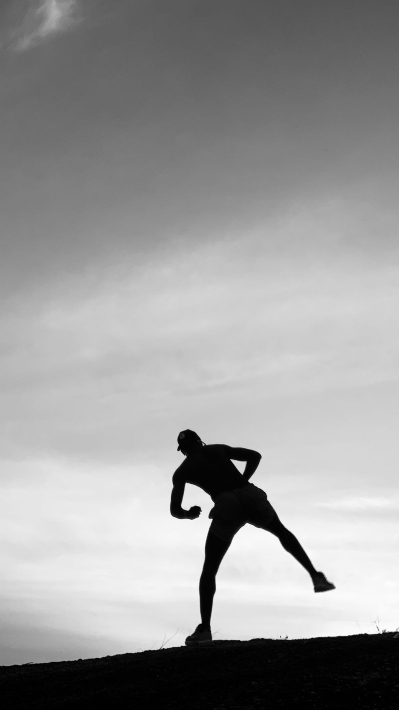 Silhouette of an athlete mid-stride against an open sky — photo by Taiye Salawu on Pexels