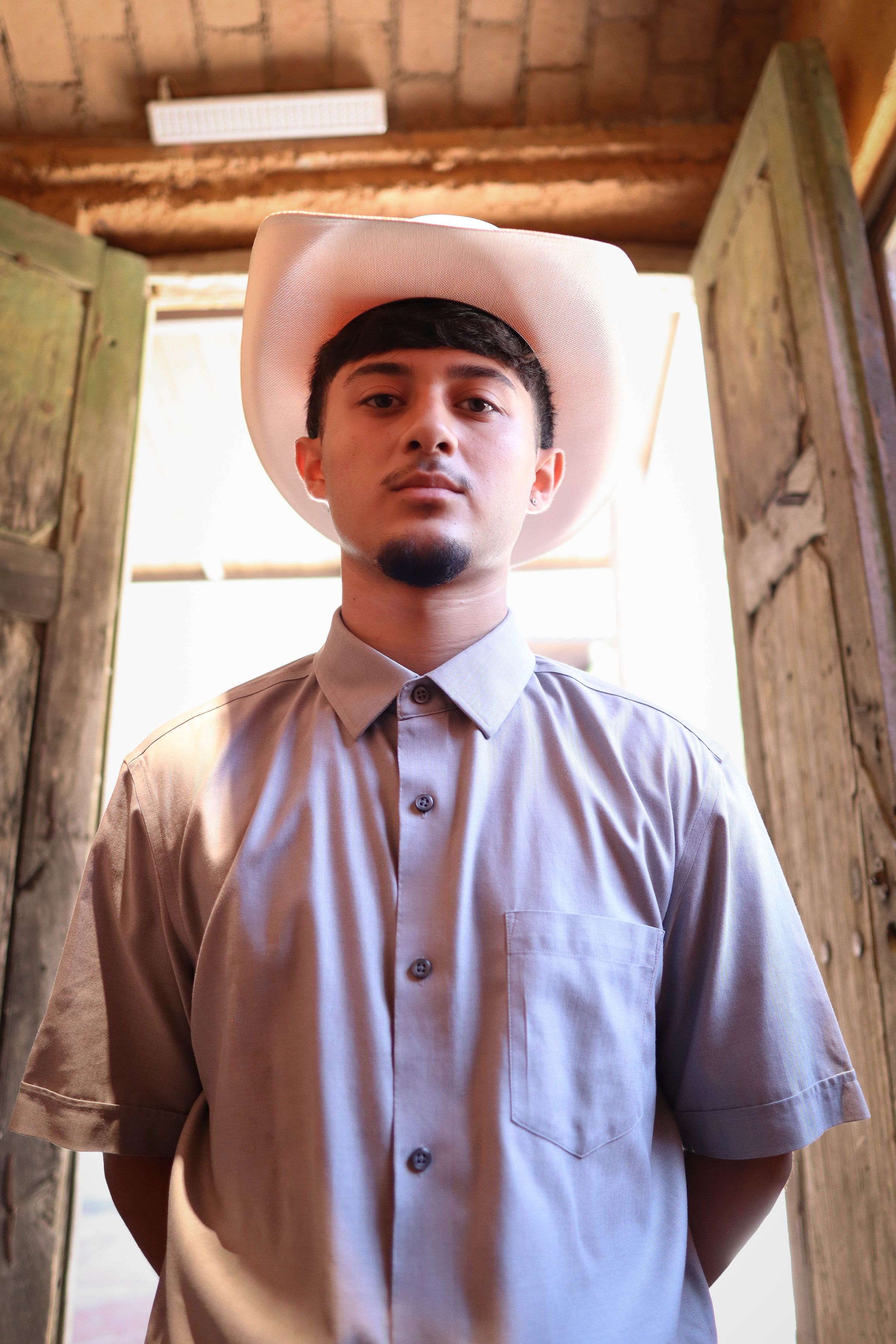 Young man wearing a traditional Mexican hat, standing indoors in León, Mexico.