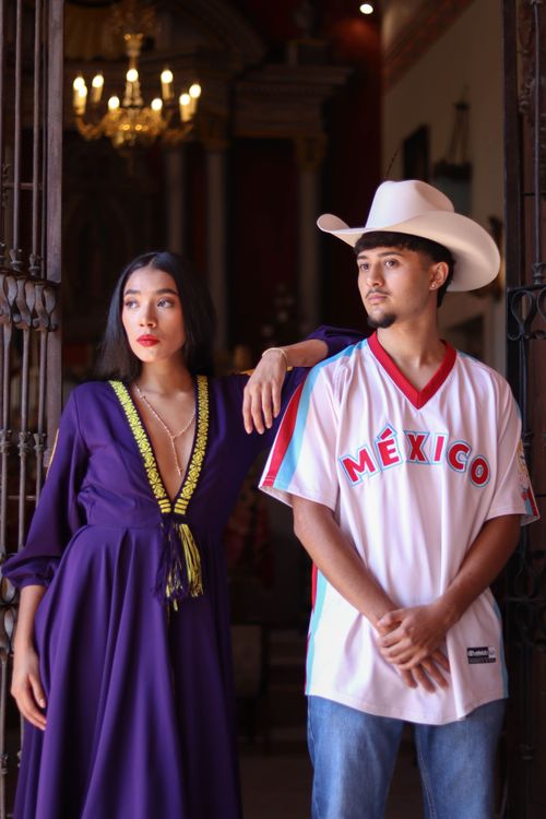 Free A fashionable Mexican couple poses in traditional dress and sports jersey, embodying modern Mexican culture. Stock Photo