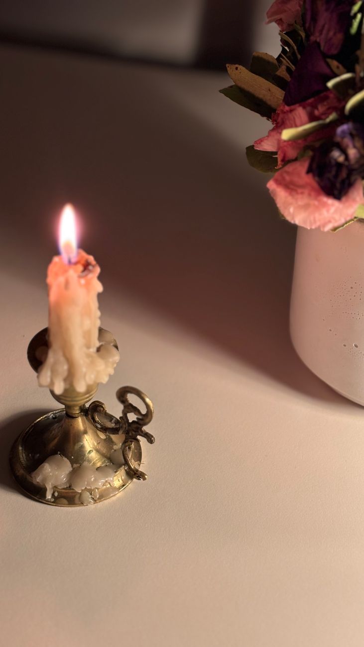 Élégante scène éclairée aux chandelles avec un bougeoir en laiton et des fleurs. Parfaite pour les ambiances cosy. - illustration