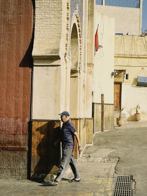 Free A man walks along the historic streets of Fes Medina in Morocco, capturing timeless architecture. Stock Photo