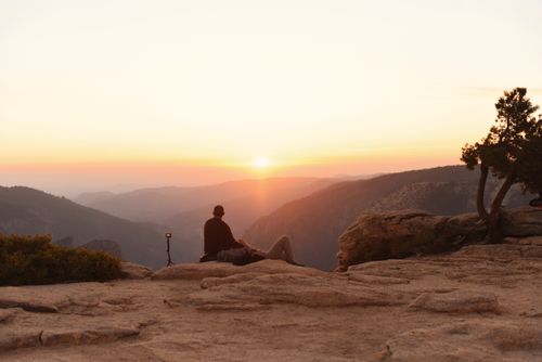 Free A person enjoying a tranquil sunrise view at Yosemite National Park, California. Stock Photo