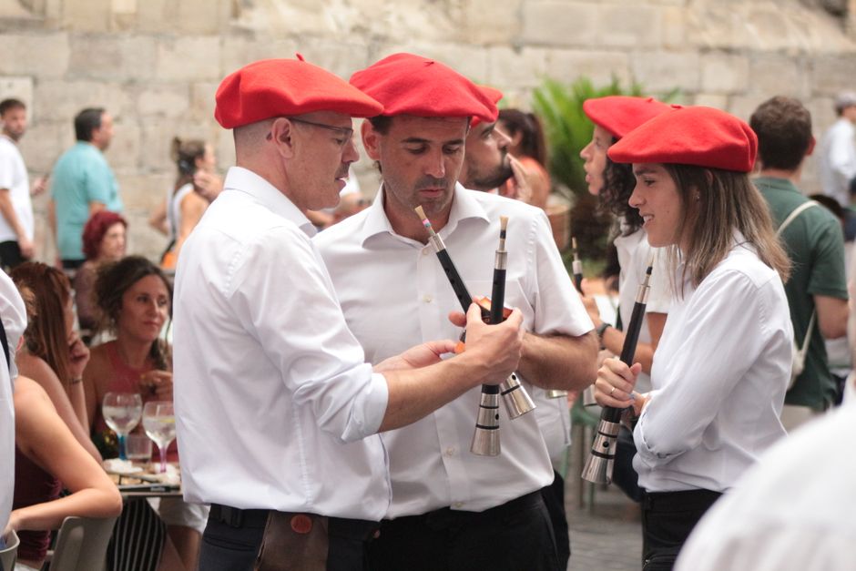 Músicos con boinas rojas tocando instrumentos tradicionales en un festival vasco.