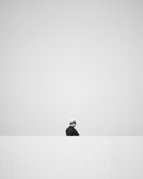 A minimalist black and white photo of a worker outdoors in Spain.