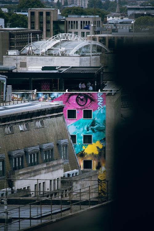 Free A vivid mural brightens a rooftop scene in London's urban landscape, featuring dynamic street art. Stock Photo