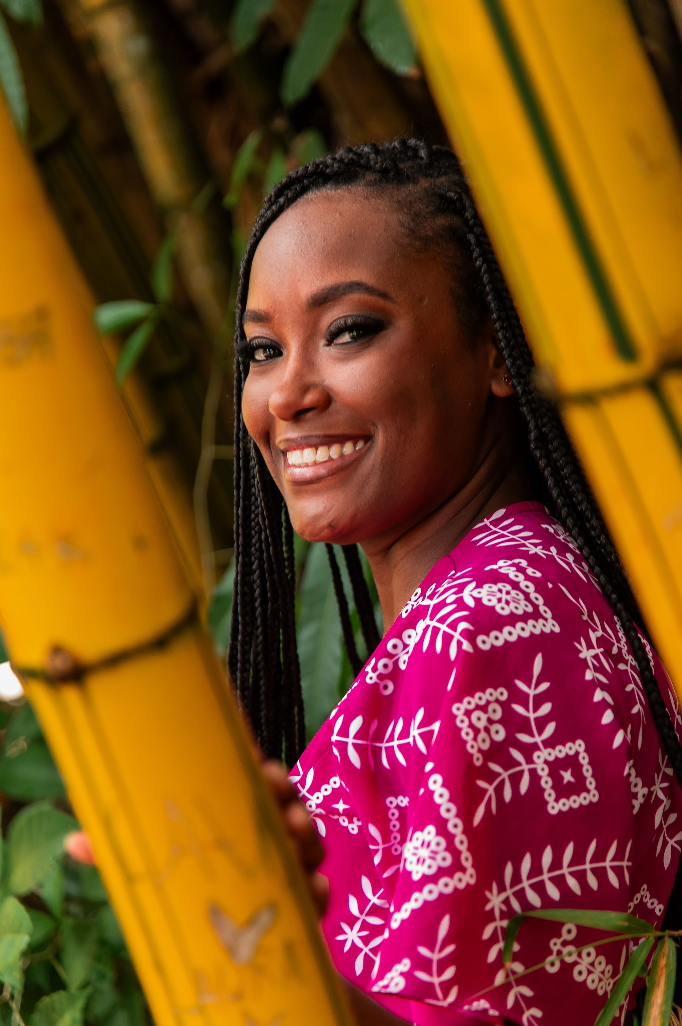Vibrant portrait of a smiling woman framed by yellow bamboo in Bahia, Brazil, exuding a joyful and tropical vibe.