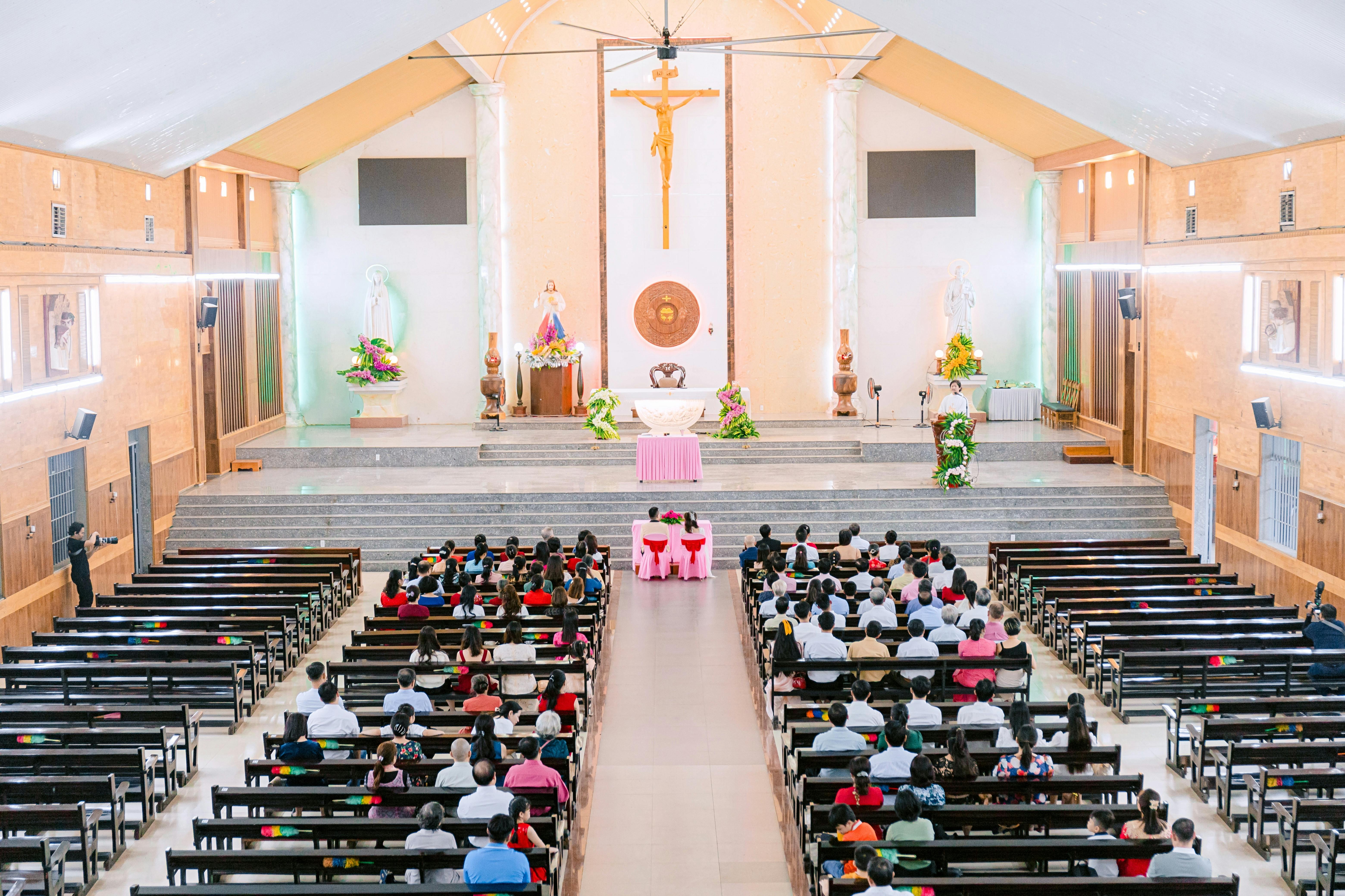 A congregation gathered in a church for a religious service with altar view.