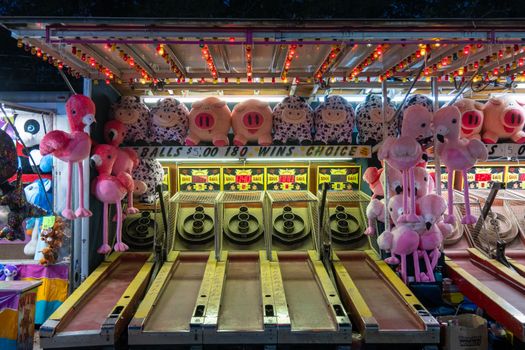 Colorful skee ball arcade with plush toys at Richmond fair, creating a vibrant amusement atmosphere.