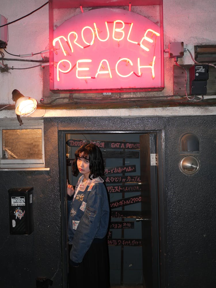 Woman Standing Near Trouble Peach Bar