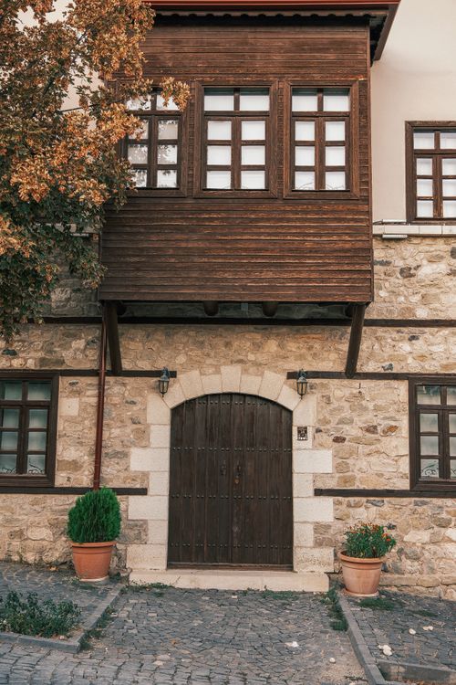 Free Charming rustic house with stone walls and wooden balcony captures a classic architectural style. Stock Photo