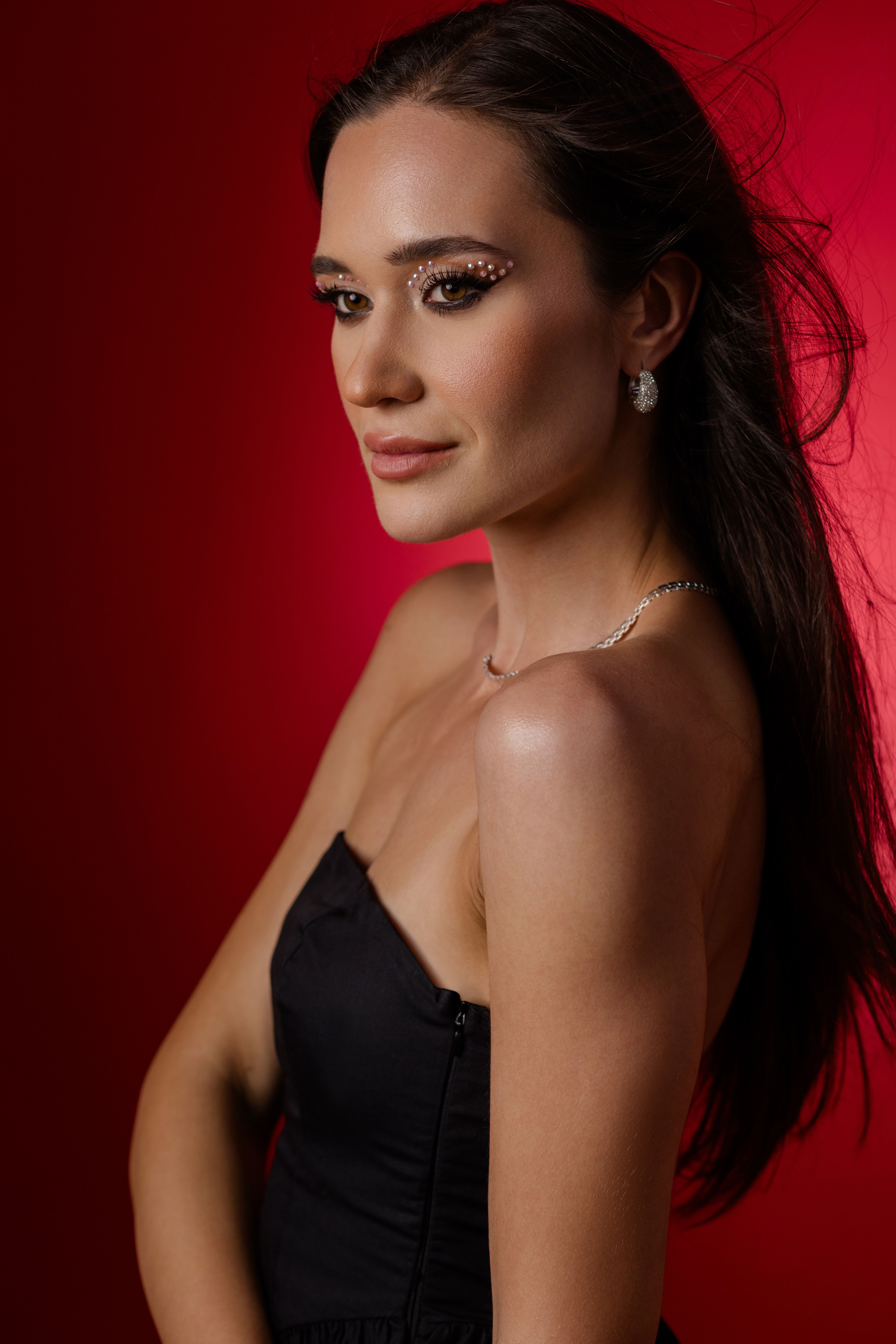 A stylish portrait of a woman against a vibrant red background showcasing elegance.