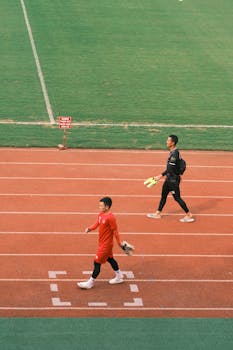 Two football players walking on a track at a stadium in Hải Phòng, Vietnam.