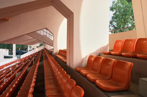 Free Empty orange stadium seats in Hải Phòng, Vietnam, during the day. Stock Photo