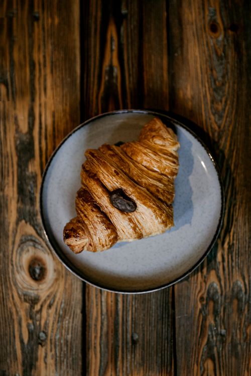 Free Delicious croissant served on a rustic wooden table, perfect for breakfast or brunch themes. Stock Photo