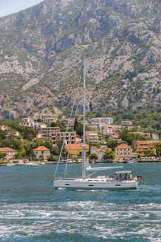 Sailboat journey with mountain backdrop and coastal town view.