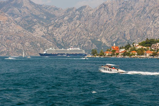 Cruise ship and speedboat in scenic Montenegro bay with mountain backdrop, offering a perfect travel moment.