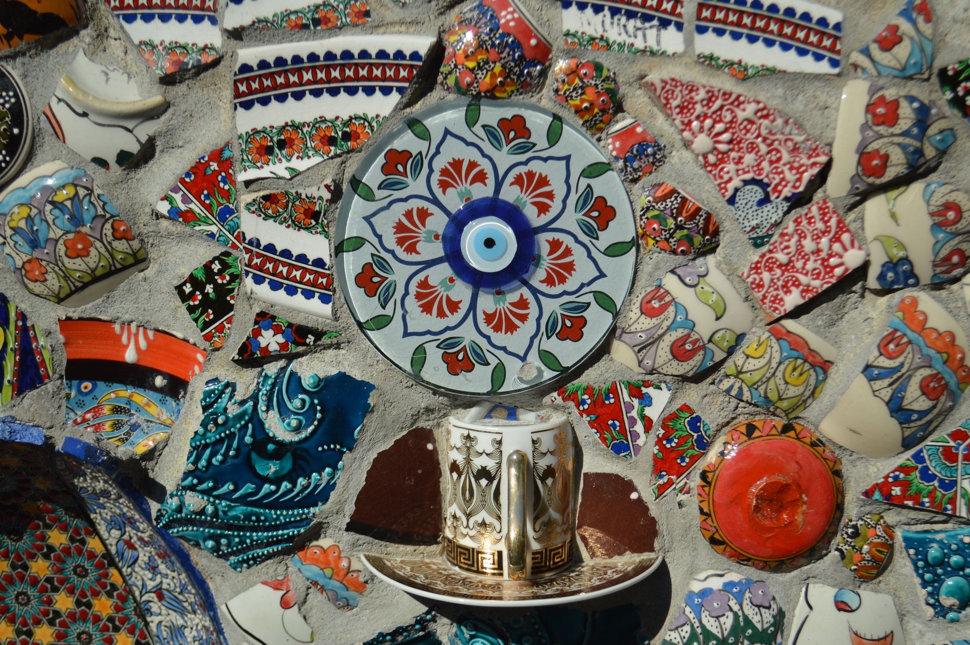 A vibrant mosaic wall featuring colorful ceramic and porcelain fragments with intricate patterns.