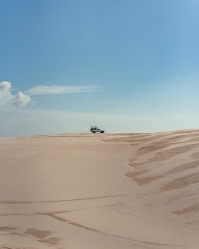 Explore the thrilling Brazilian dunes with a 4x4 under the clear blue sky.