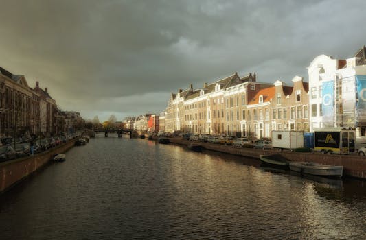 Beautiful view of a historic canal in Haarlem under dramatic clouds.