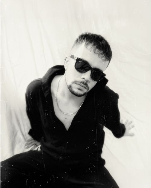 Free Artistic black and white portrait of a man in sunglasses wearing a chain. Stock Photo