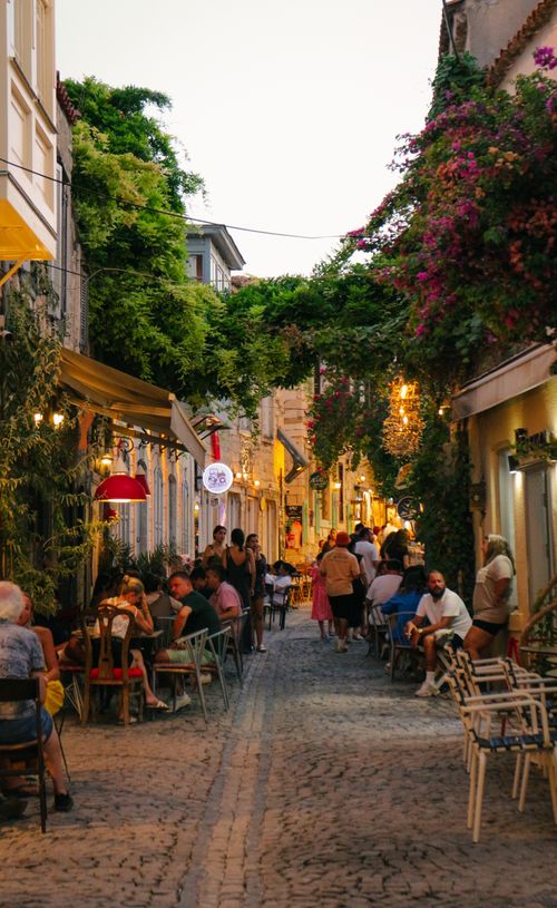 Free A vibrant Mediterranean street cafe bustling with people in the evening. Stock Photo