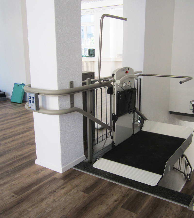 Platform lift in a rehabilitation facility promoting handicap accessibility and mobility aid support.