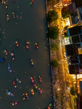 Aerial view of colorful lit boats on the river in Hội An, Vietnam, showcasing the vibrant nightlife and culture.