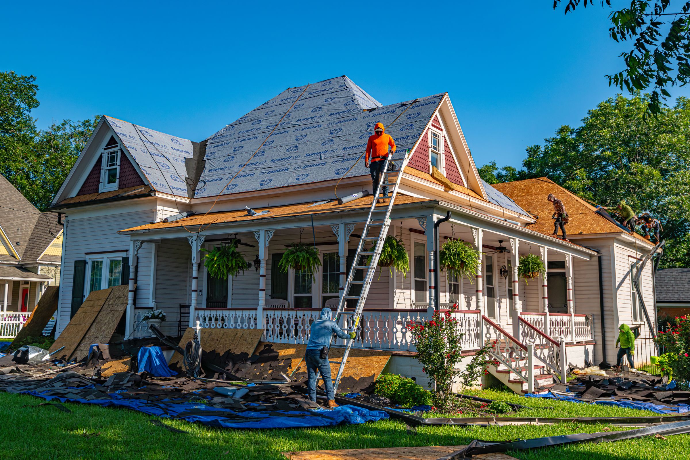 Roofers replacing the roof of a historic home, full tear-off in progress