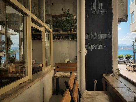Warm, inviting cafe interior with rustic decor and seaside view, perfect for relaxation.