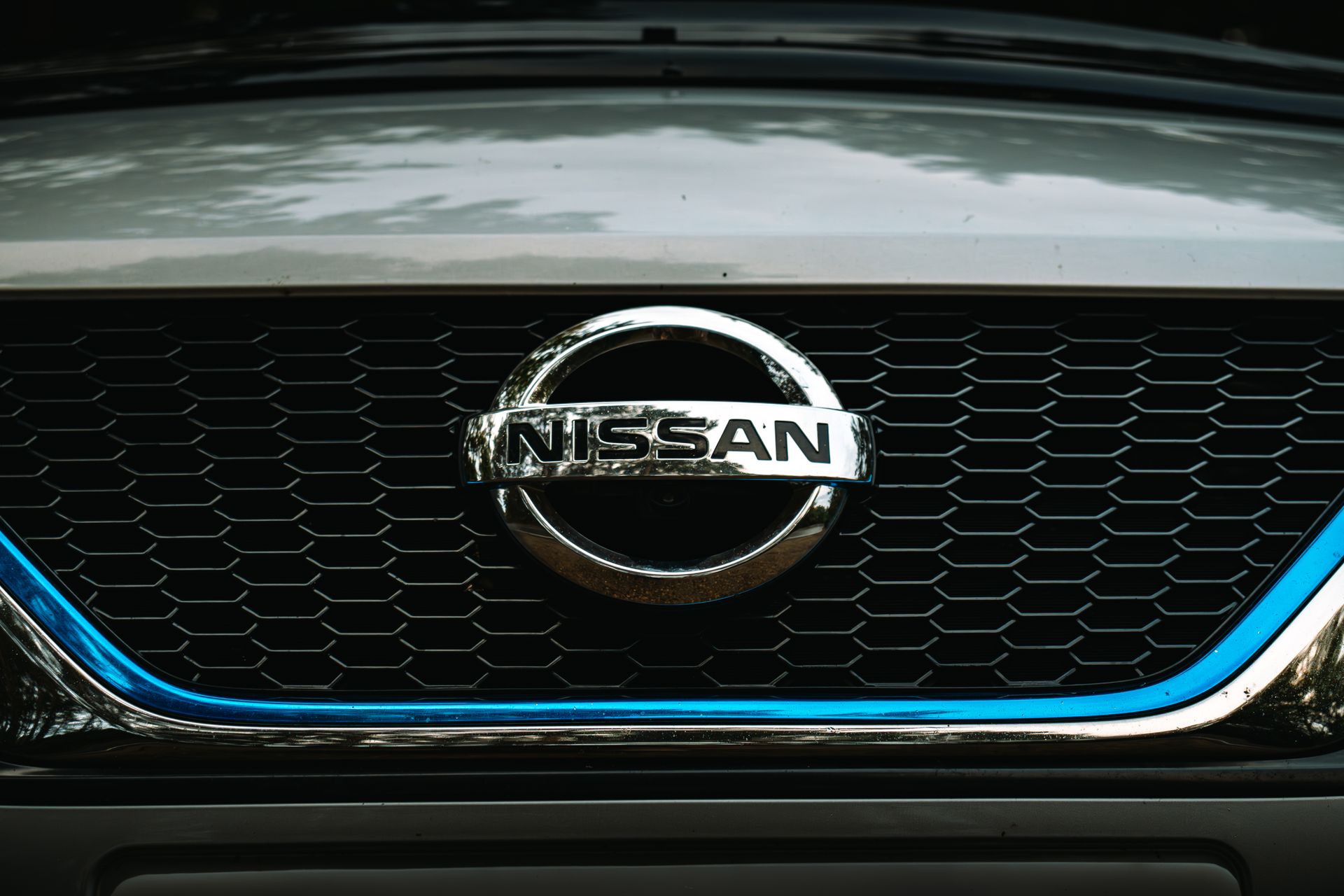 Detailed view of a car brand logo on the front grille, showing intricate design and texture.