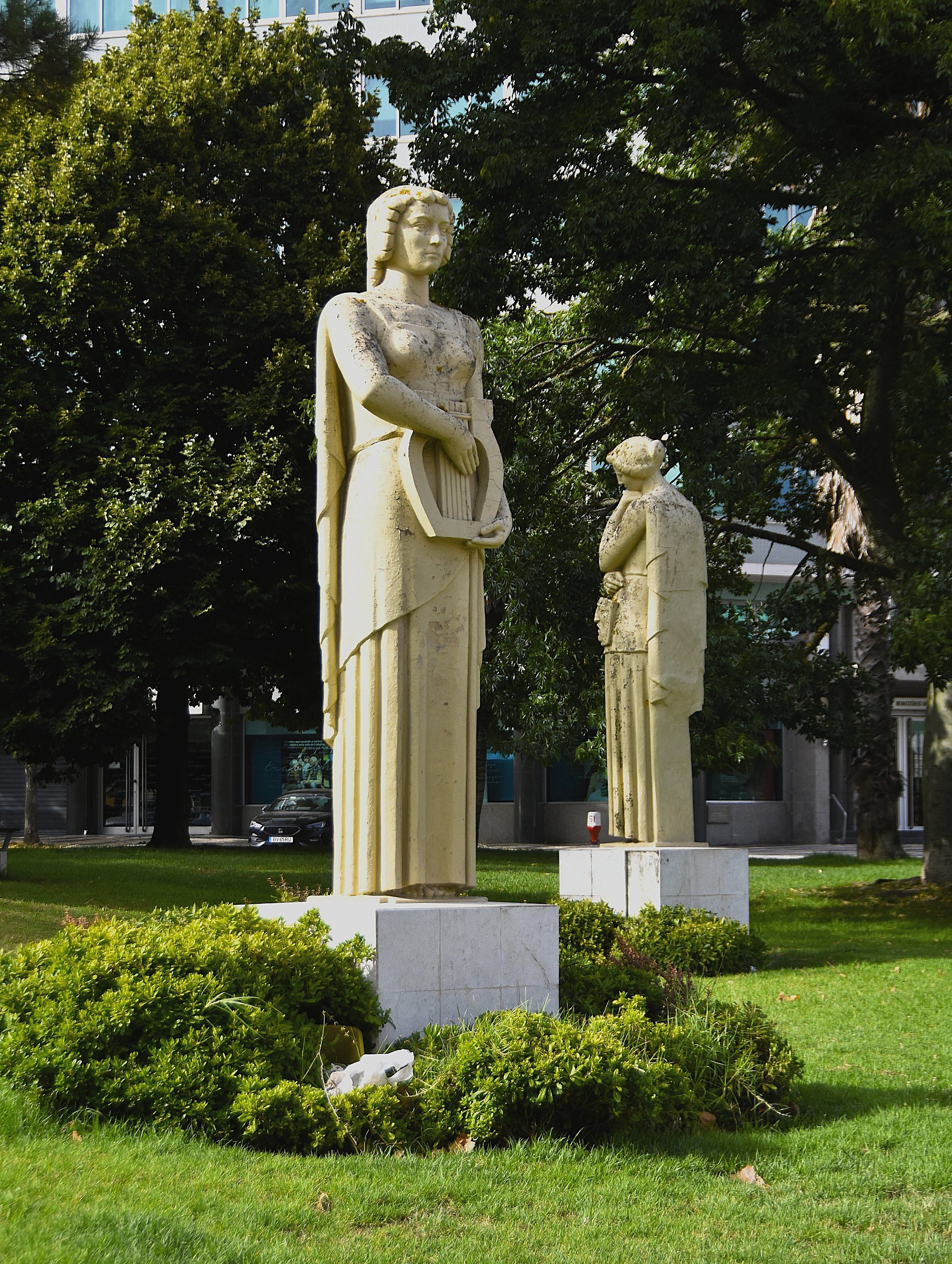 Stone statues in Eduardo VII Park, Lisbon on a sunny day, showcasing classic architecture.