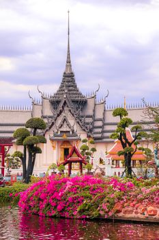 Beautiful Thai temple surrounded by garden blooms in Samut Prakan, Thailand, captured during the day.