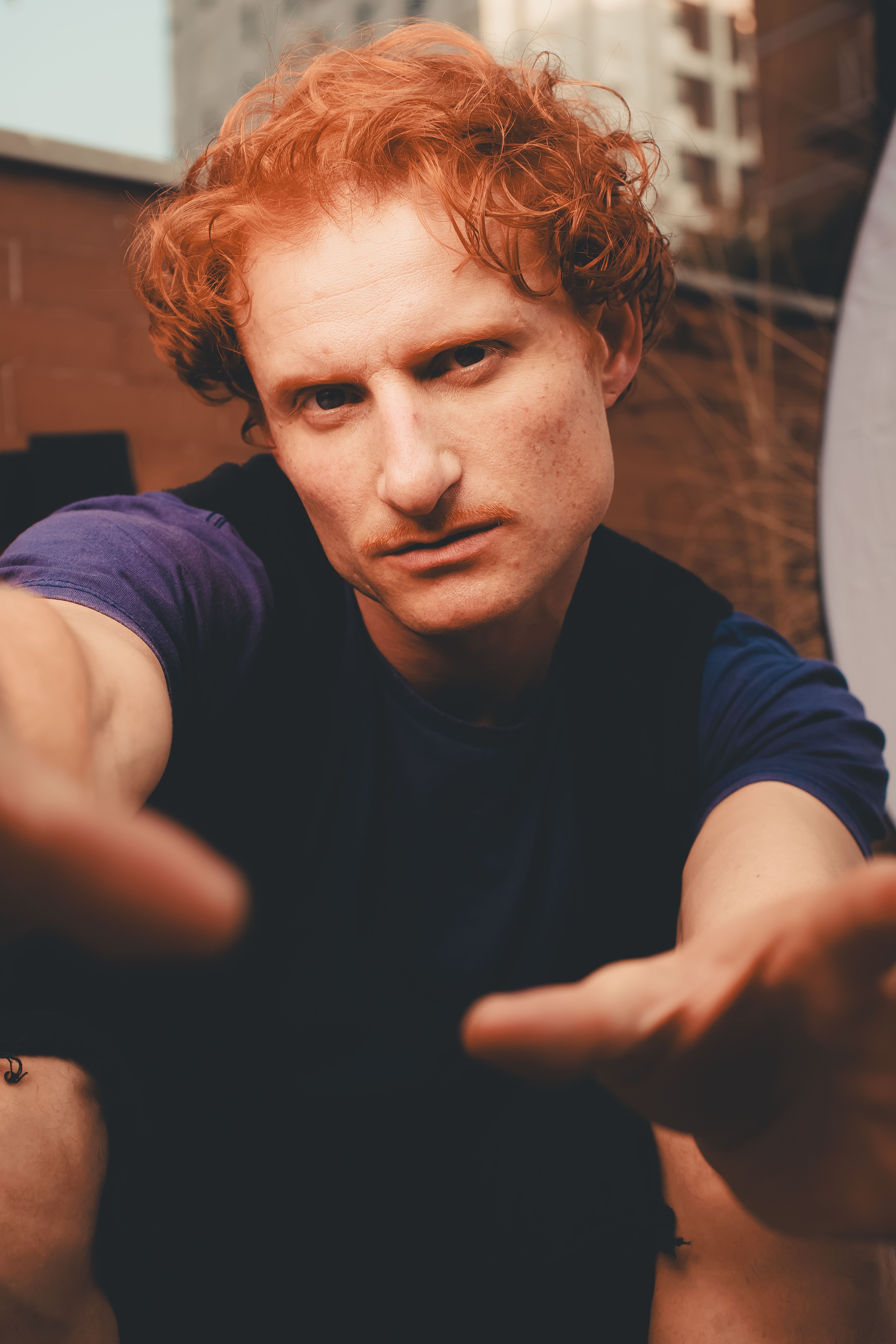 Close-up portrait of a red-haired man with an intense expression captured outdoors in São Paulo, Brazil.