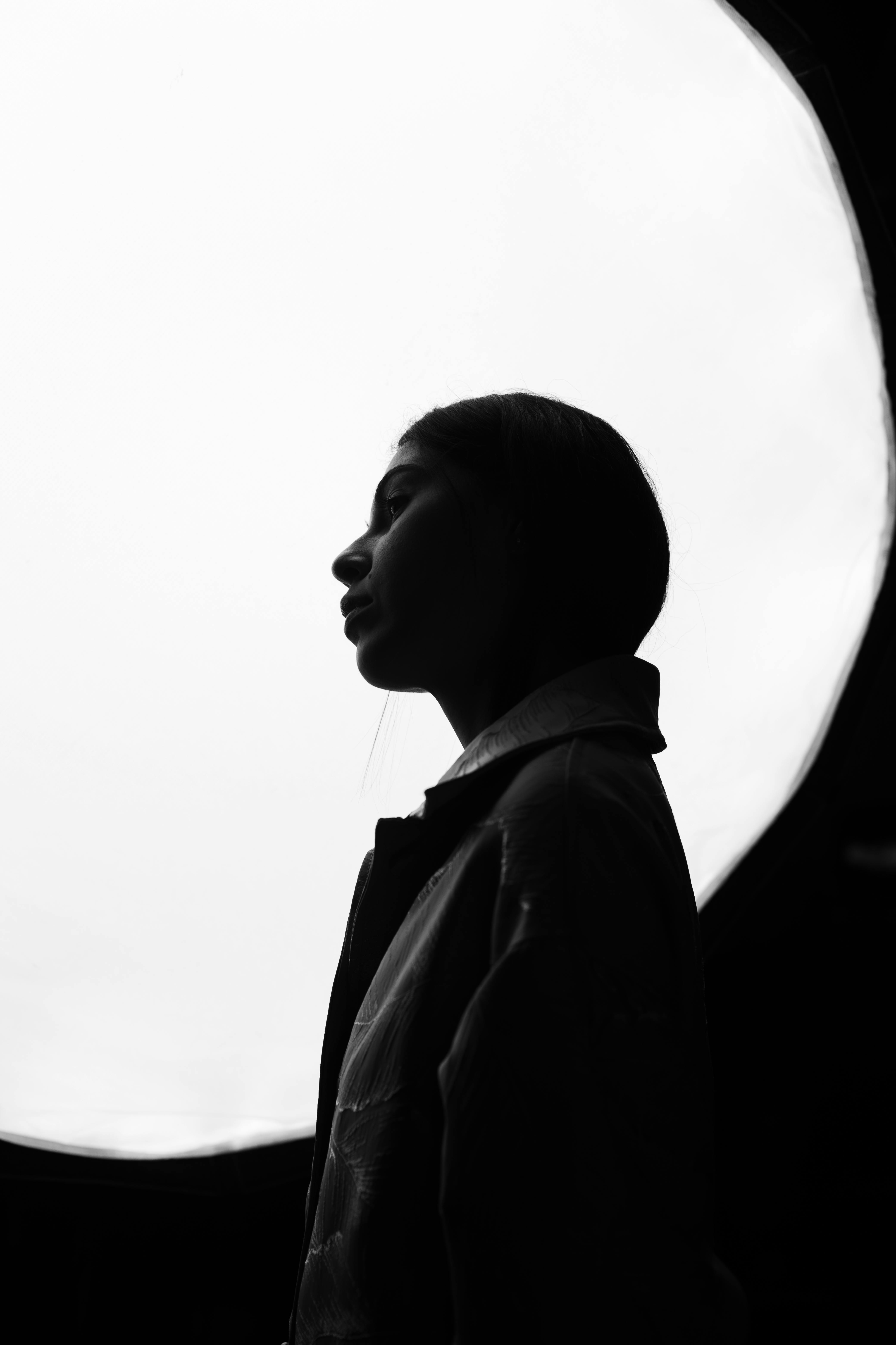 Artistic silhouette of a woman in studio lighting, creating a dramatic monochrome effect.
