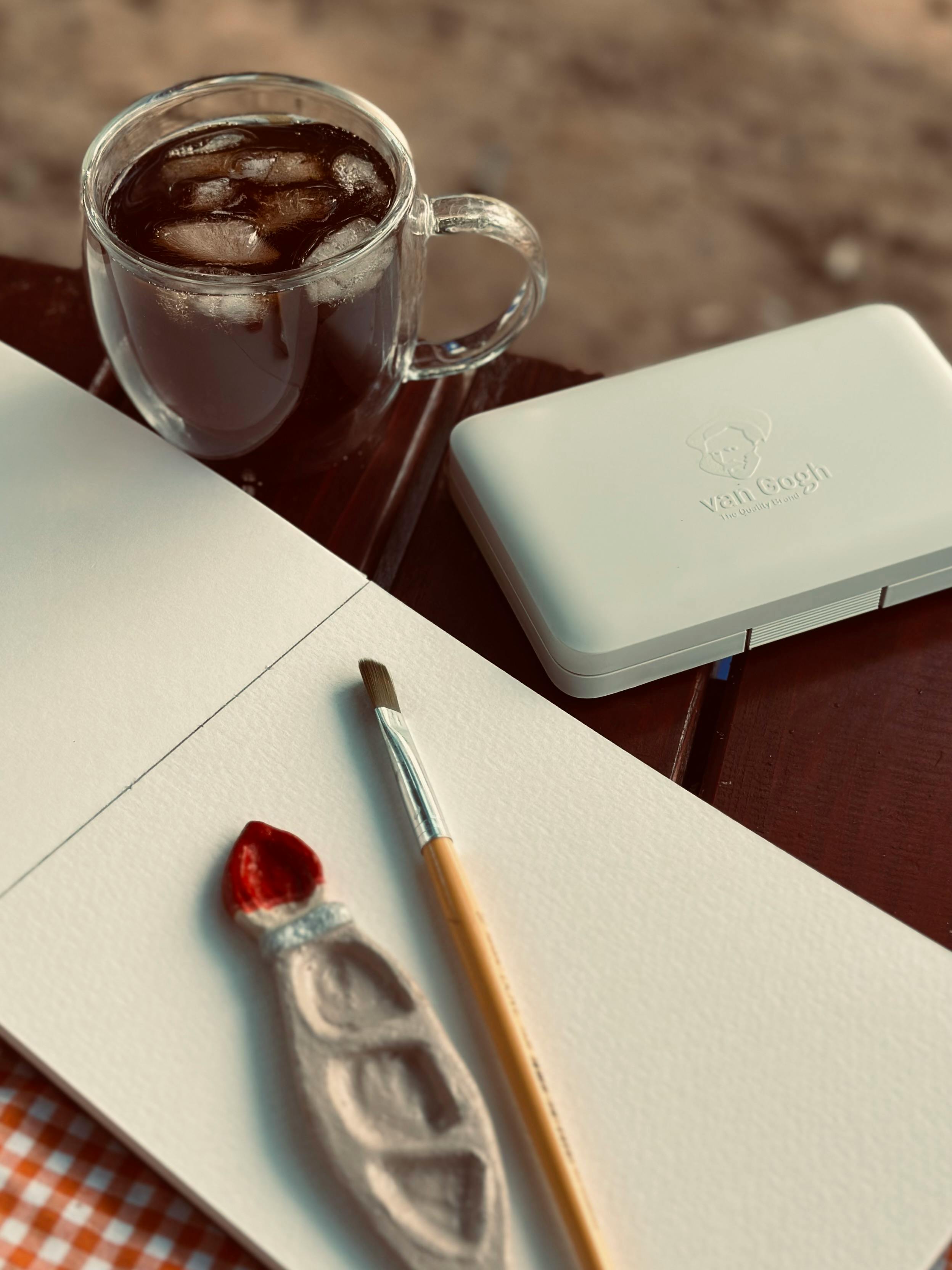 Gratis Acogedor espacio de trabajo artístico con un vaso de café helado y pinturas de acuarela. Foto de stock