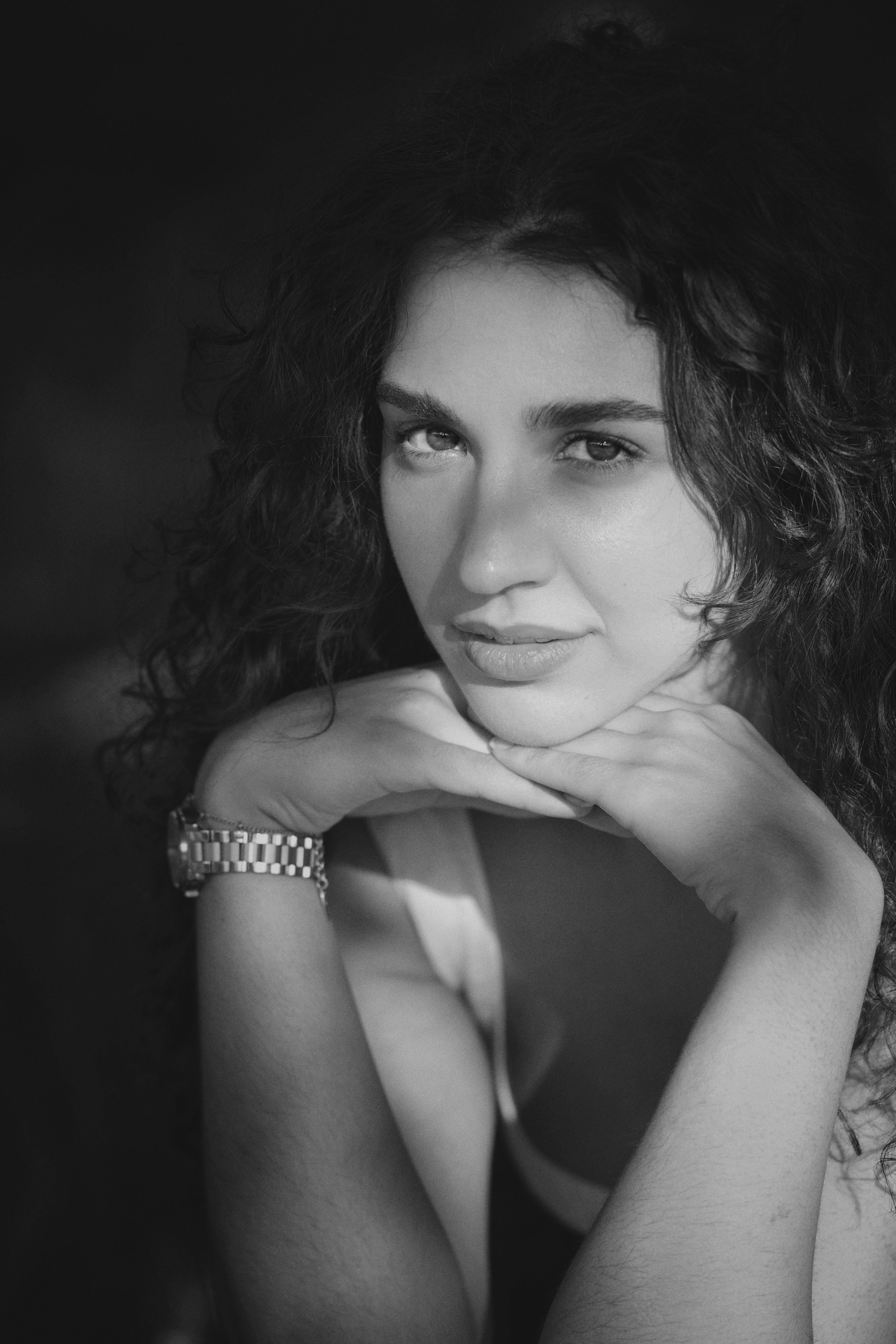Striking black and white portrait capturing a thoughtful young woman, emphasizing elegance and emotion.