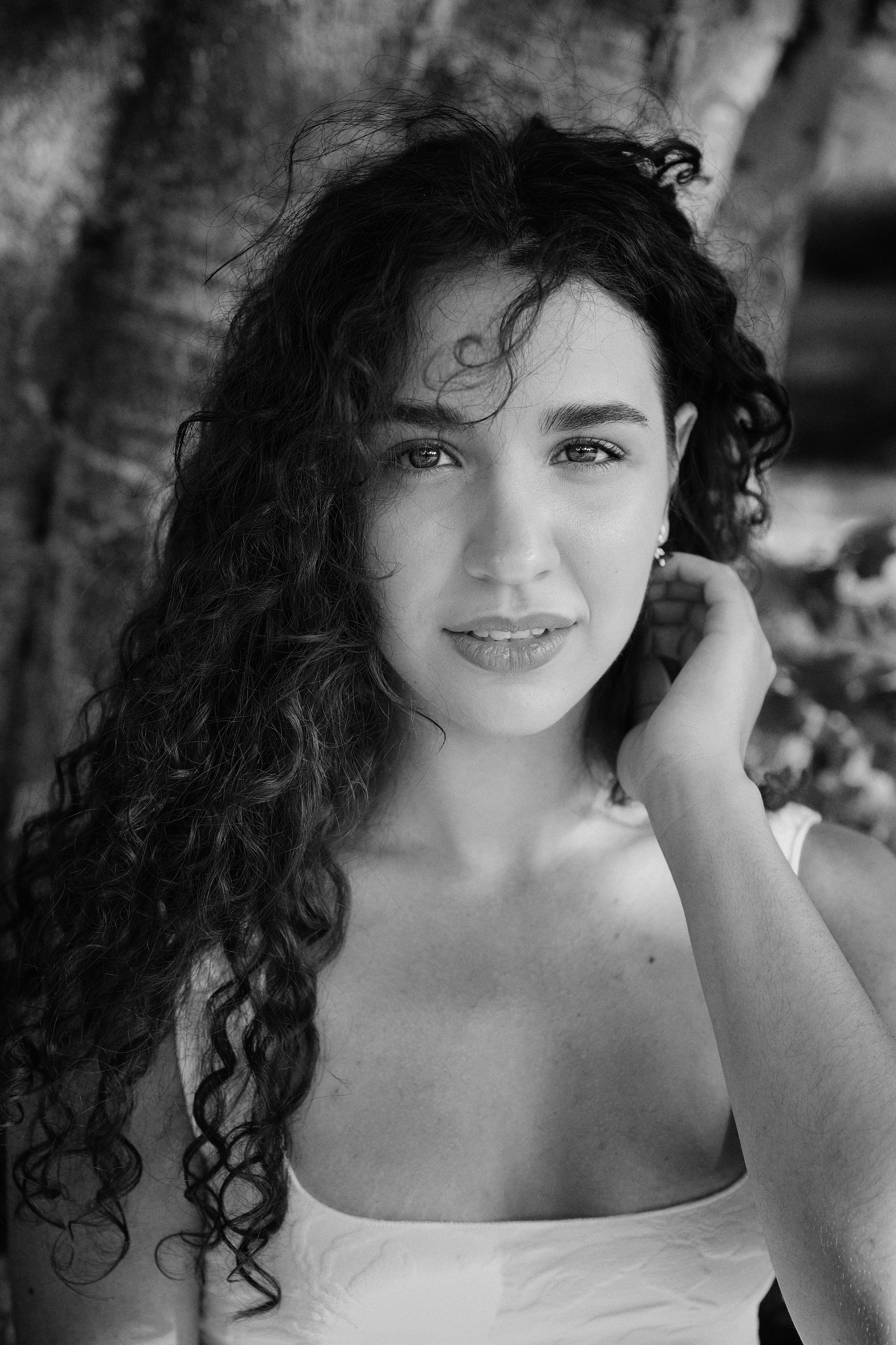 A captivating black and white portrait of a young woman with curly hair.