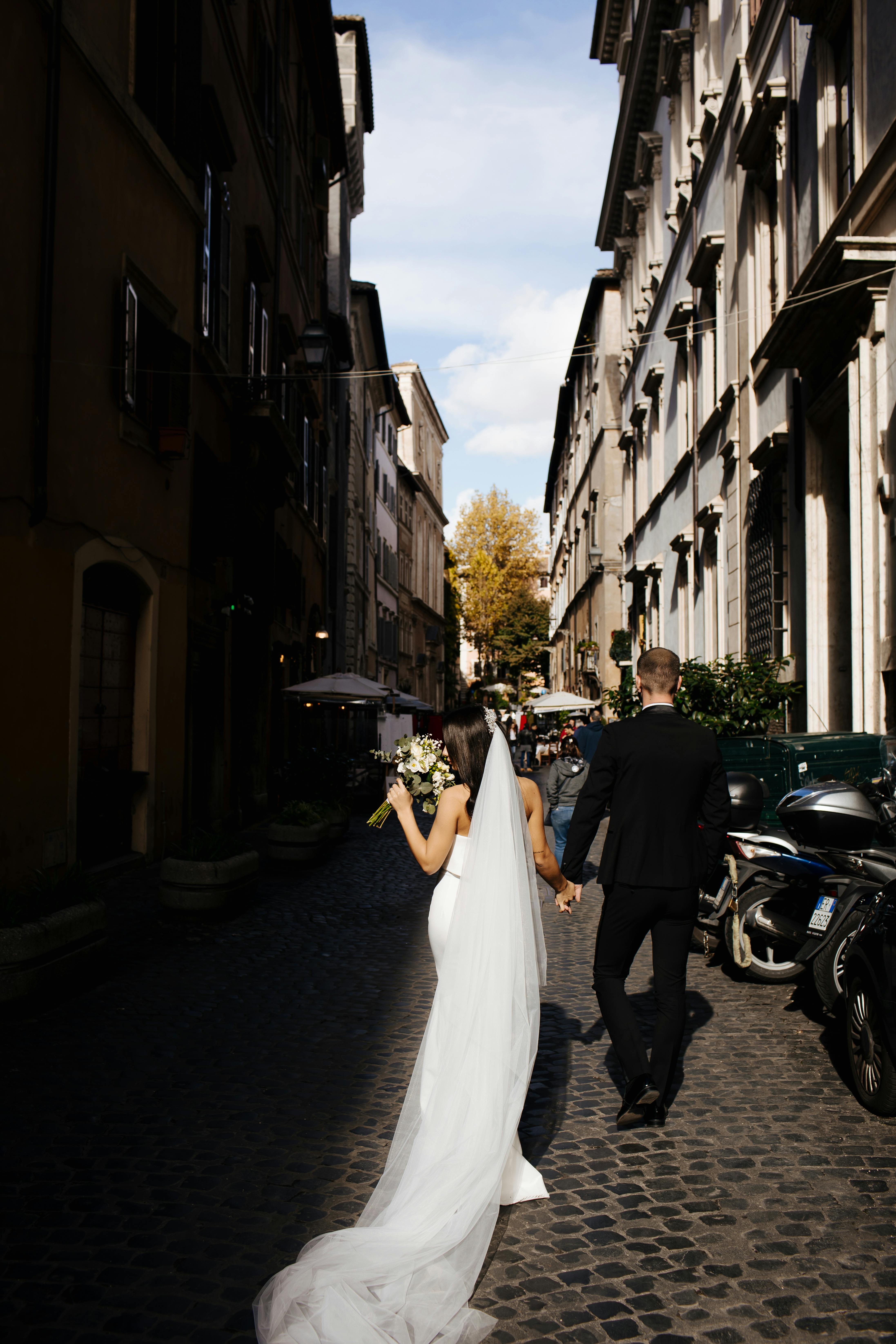 photo of couple walking on cobblestone street