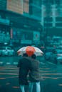 Two people with umbrella on rainy city street