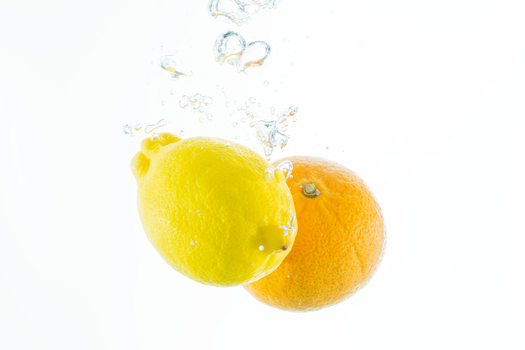 Vibrant lemon and orange splash into water showcasing freshness and vitality.