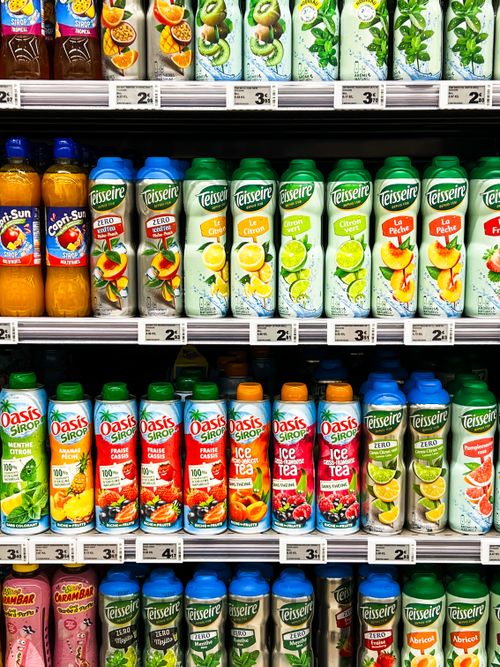 Free Vibrant shelves in a supermarket in Calais, France, displaying diverse fruit juice bottles. Stock Photo
