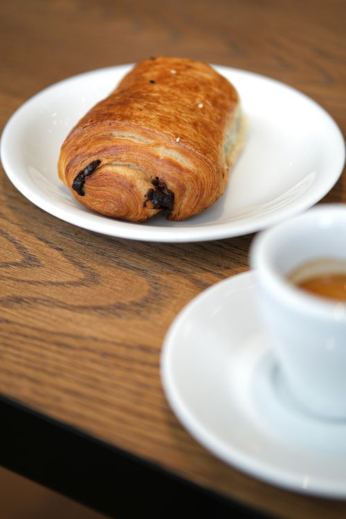 Free A freshly baked chocolate croissant served with hot espresso on a wooden table. Stock Photo