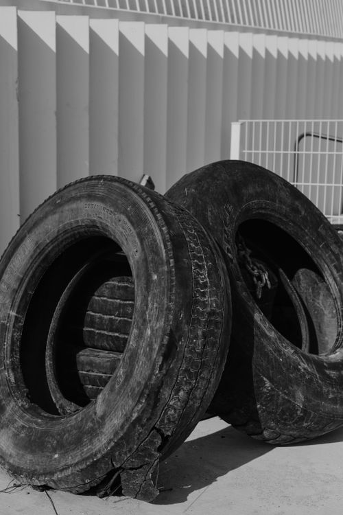 Free A black and white image of abandoned tires against an architectural backdrop in İstanbul. Stock Photo