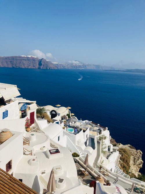 Free Captivating photo of Oia, Greece, showcasing iconic white buildings against the sparkling blue Aegean Sea. Stock Photo