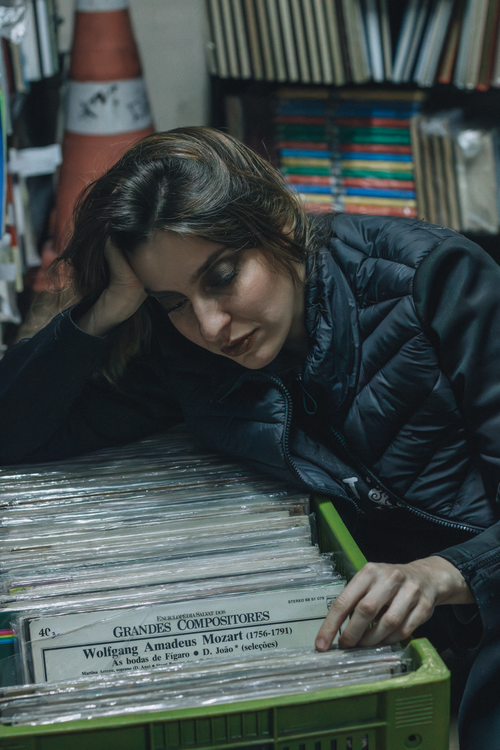 Free Young woman exploring vinyl records in a vintage music store. Stock Photo