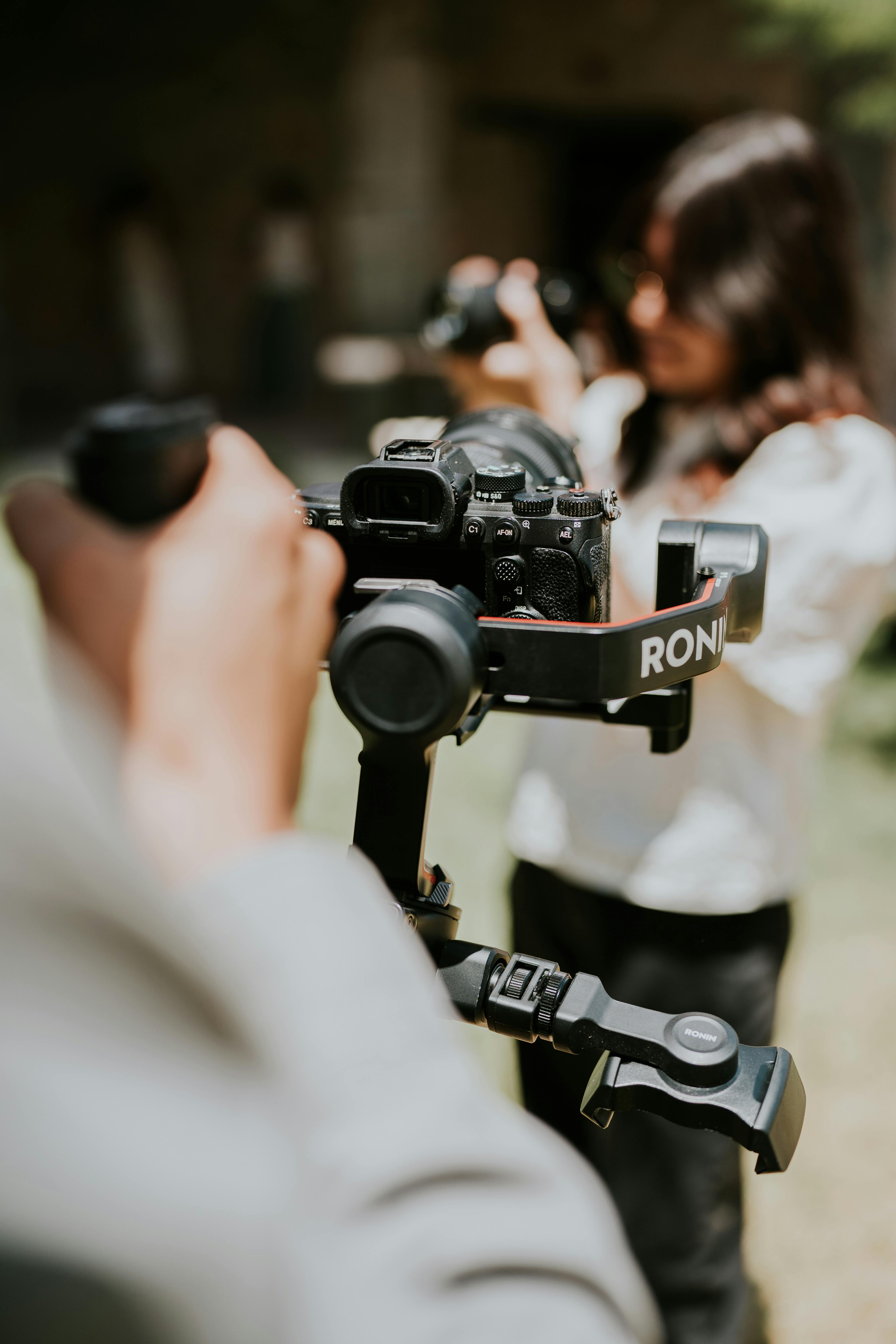 Photographers using stabilizers to capture outdoor shots, emphasizing modern photography techniques.